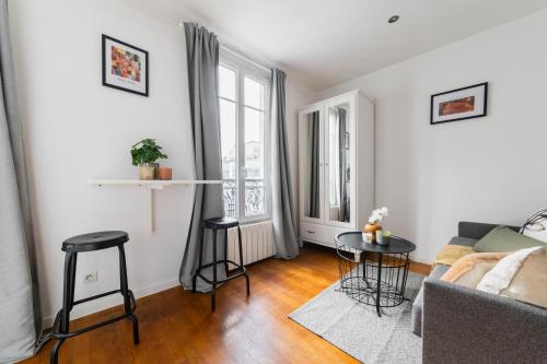 un salon avec un canapé et une table dans l'établissement Cosy Apt Batignoles, à Paris