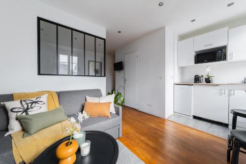 un salon avec un canapé et une table dans l'établissement Cosy Apt Batignoles, à Paris