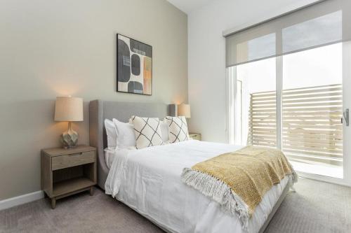 a white bedroom with a bed and a window at Landing - Modern Apartment with Amazing Amenities (ID3121X08) in Las Vegas