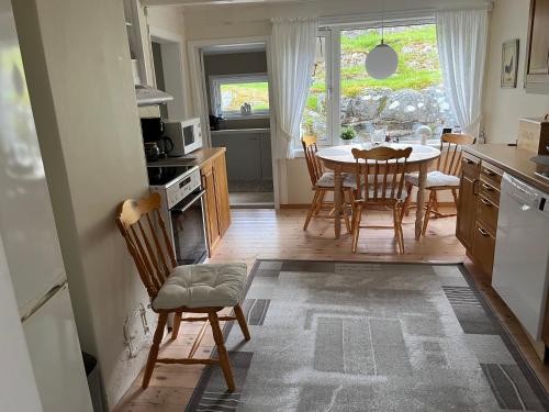 uma cozinha com mesa e cadeiras e uma sala de jantar em Sjarmerende gårdsbruk omgitt av vakker natur em Molde