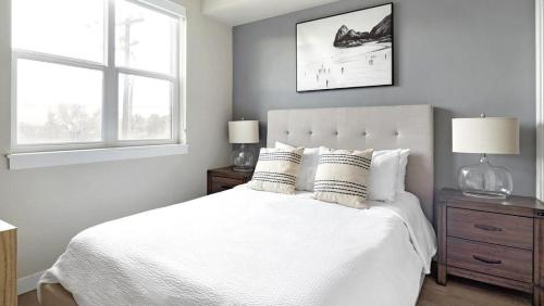 um quarto com uma cama branca e 2 janelas em Landing - Modern Apartment with Amazing Amenities (ID7703X6) em Salt Lake City