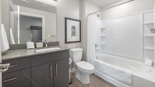 a white bathroom with a toilet and a bath tub at Landing - Modern Apartment with Amazing Amenities (ID7703X6) in Salt Lake City