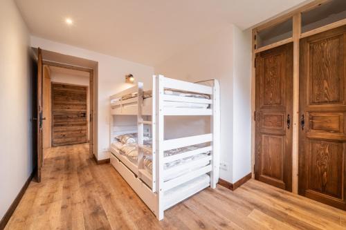 a white closet with wooden floors and wooden doors at Chalet de la Joux in Saint-Sigismond