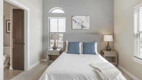 1 dormitorio con 1 cama grande con almohadas azules en Landing - Modern Apartment with Amazing Amenities (ID3874), en Carrollton