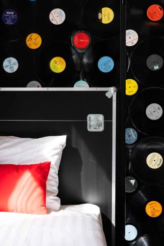 a bedroom with a wall with records on the wall at Backstage Hotel Amsterdam in Amsterdam