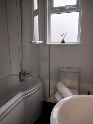 a bathroom with a sink and a toilet and a window at Wyoming Cottage in York