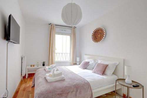 a white bedroom with a bed and a television at 340 Suite Emile - Superb apartment in Clichy
