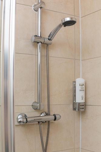 a shower with a shower head in a bathroom at Islington Inn in London