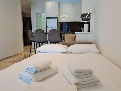 - un lit blanc avec 3 serviettes dans l'établissement Luxury Suite Patras (2), à Patras