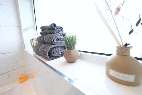 a pile of towels sitting on a window sill at 1 BEDROOM FLAT IN WOOD GREEN PICCADILLY LINE in London