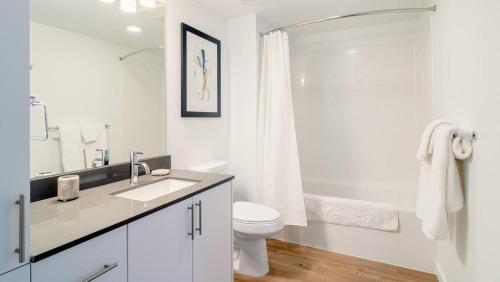 La salle de bains blanche est pourvue d'une douche et de toilettes. dans l'établissement Landing - Modern Apartment with Amazing Amenities (ID5770X40), à Everett