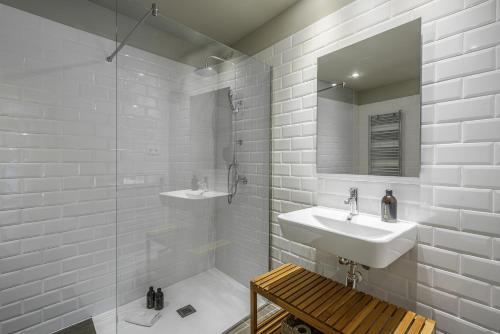 a bathroom with two sinks and a shower and a mirror at Ola Living Hostal Diagonal in Barcelona