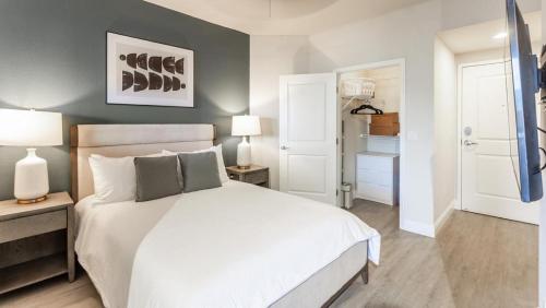 ein Schlafzimmer mit einem Bett, zwei Lampen und einem Schrank in der Unterkunft Landing - Modern Apartment with Amazing Amenities (ID8458X06) in Miami