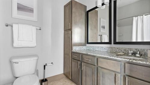 La salle de bains est pourvue de toilettes, d'un lavabo et de miroirs. dans l'établissement Landing - Modern Apartment with Amazing Amenities (ID7923X25), à Spring Hill