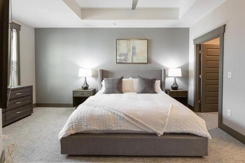 een slaapkamer met een groot bed met 2 nachtkastjes en 2 lampen bij Landing - Modern Apartment with Amazing Amenities (ID2257) in Dallas