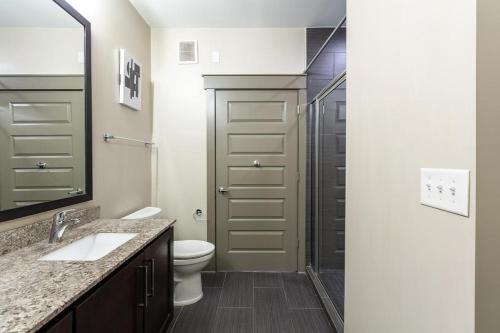 een badkamer met een douche, een toilet en een wastafel bij Landing - Modern Apartment with Amazing Amenities (ID2257) in Dallas