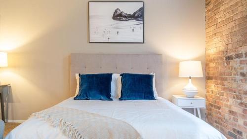 um quarto com uma cama grande e almofadas azuis em Landing - Modern Apartment with Amazing Amenities (ID5125X39) em Chicago