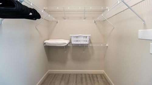 a walk in closet with white walls and a shelf at Landing - Modern Apartment with Amazing Amenities (ID8251X95) in Wake Forest