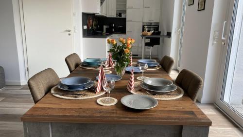einen Esstisch mit Stühlen und einen Holztisch mit Tellern in der Unterkunft Ferienhaus Helfert FeWo 1 in Niemtsch