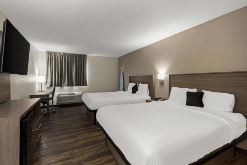 Habitación de hotel con 2 camas y escritorio en Red Lion Inn & Suites Caseyville, en Caseyville