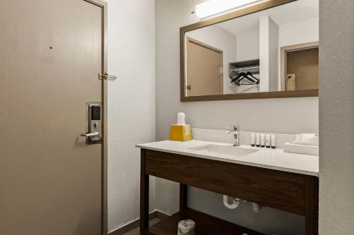 a bathroom with a sink and a mirror at Red Lion Inn & Suites Caseyville in Caseyville