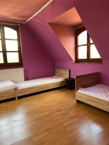 a attic room with two beds and purple walls at BRC Hostel & Car Rent Budapest in Budapest