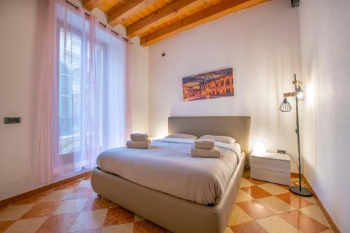 - une chambre avec un lit et une grande fenêtre dans l'établissement Palace Home Mazzini Verona Center 1, à Vérone