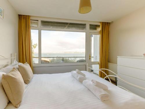 a bedroom with a white bed with a large window at 3 bed property in Brixham BX034 in Brixham