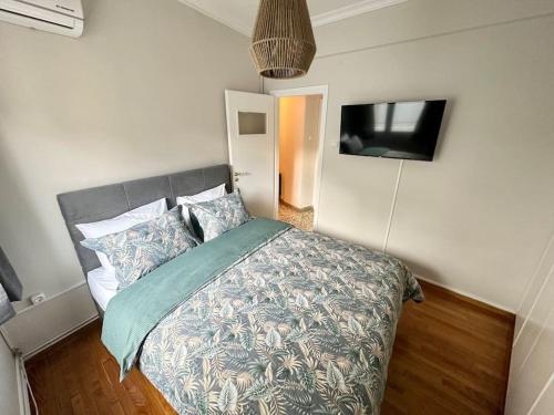 a bedroom with a bed and a flat screen tv at Central House in Plaka in Athens