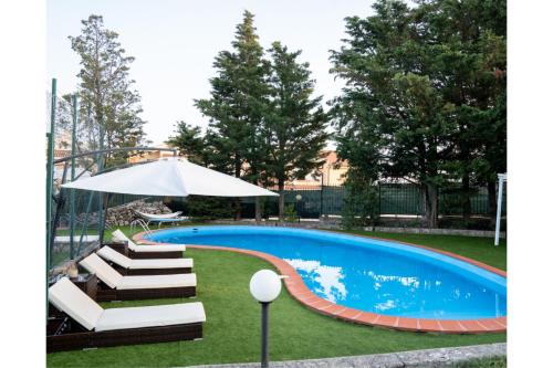 una piscina con sedie a sdraio e ombrellone di Villa Artemide a Manfredonia