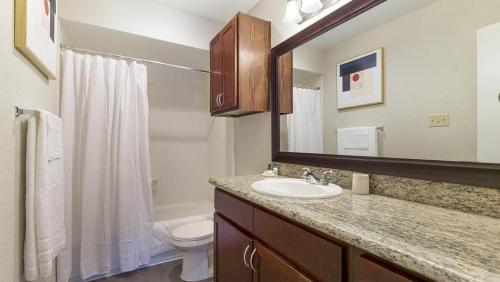 uma casa de banho com um lavatório, um WC e um espelho. em Landing - Modern Apartment with Amazing Amenities (ID9254X75) em Houston