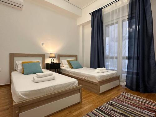 twee bedden in een kamer met een raam bij Superb New Family Apartment vipgreece in Athene