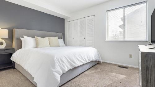 a white bedroom with a bed and a window at Landing - Modern Apartment with Amazing Amenities (ID9305X02) in Ballwin