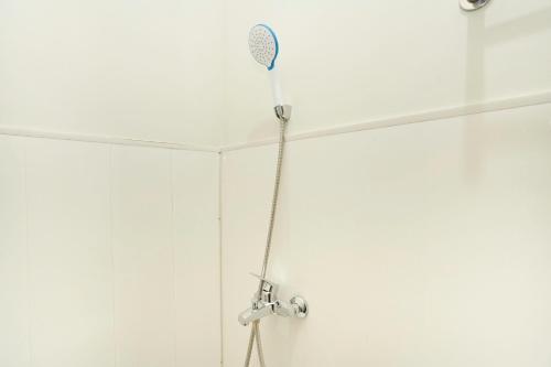 La salle de bains est pourvue d'une douche avec un pommeau de douche. dans l'établissement SUPER OYO Flagship 3688 Pot Art, à Surabaya