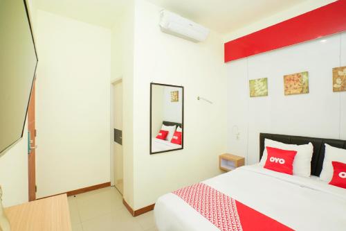 - une chambre avec un grand lit et des oreillers rouges dans l'établissement SUPER OYO Flagship 3688 Pot Art, à Surabaya