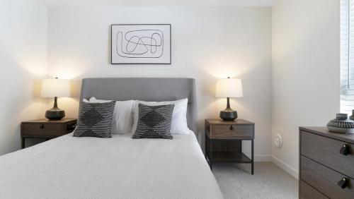 um quarto com uma cama com duas mesas de cabeceira e dois candeeiros em Landing - Modern Apartment with Amazing Amenities (ID8324X58) em Woodinville