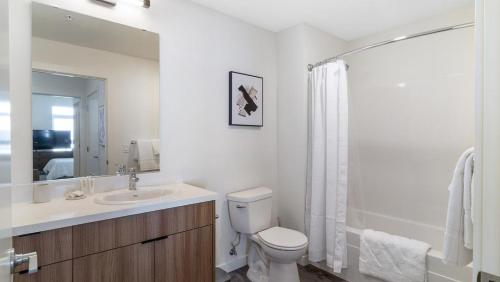 uma casa de banho branca com um WC e um lavatório em Landing - Modern Apartment with Amazing Amenities (ID8324X58) em Woodinville