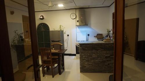 a kitchen with a table and chairs and a refrigerator at The Whitegates Lodge in Weligama