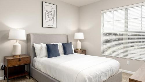 Un dormitorio con una cama con almohadas azules y una ventana en Landing - Modern Apartment with Amazing Amenities (ID8701X65) en Dublin