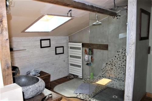 La salle de bains est pourvue d'un lavabo et d'une lucarne. dans l'établissement le Roc blanc, à Veyrignac