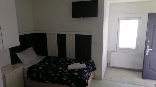 a bedroom with a bed and a television on the wall at Kai Hotel Bar in Tbilisi City