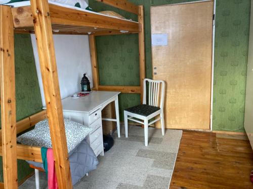 Schlafzimmer mit einem Schreibtisch und einem Etagenbett in der Unterkunft Old Cozy Wood House in Rovaniemi