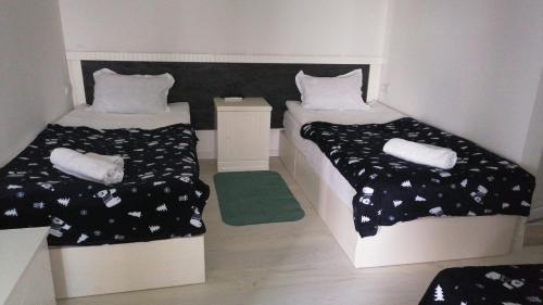- 2 lits dans une petite chambre avec un tapis vert dans l'établissement Kai Hotel, à Tbilissi