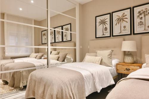 two beds in a room with mirrors at For You Rentals Elegante y cómodo apartamento en Goya FBR18 in Madrid
