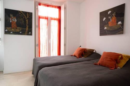 two beds in a room with a window at Tings Lisbon in Lisbon