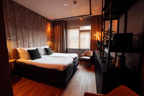 a bedroom with a bed and a television in it at Boutique Hotel, Restaurant & Wellness Westerburcht in Westerbork