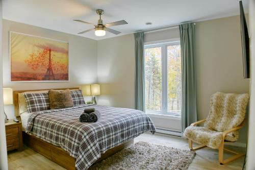a bedroom with a bed and a chair at Cottage le Cerf (modern, spa, BBQ, accès lac Lili) in Chertsey