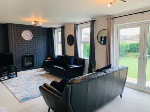 a living room with a couch and a tv at Chic 5 Bedroom House with Private Parking & Garden in Bristol