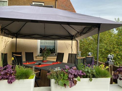 a patio with a table and a large umbrella at im Haus zur Auszeit willkommen in Ruhla