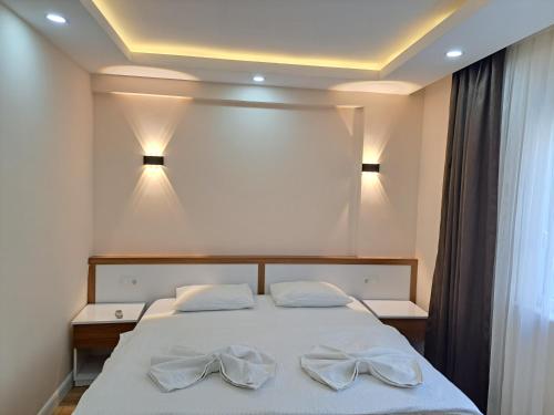 Ada APART&HOTEL في أنطاليا: غرفة نوم عليها سرير وفوط بيضاء